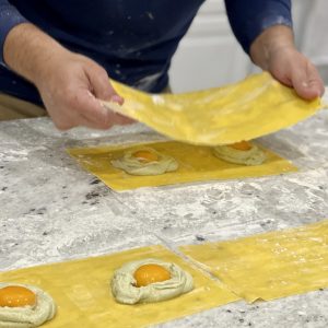 Chef covering the egg with pasta